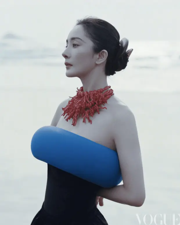 杨幂身着蓝调造型,搭配红饰颈链,侧颜线条精致柔和。