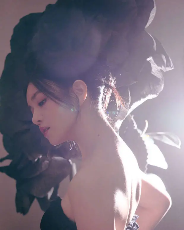 陈妍希侧颜出镜，发丝与巨型黑玫瑰相融，暖光勾勒肩颈线条，神态松弛冷艳。