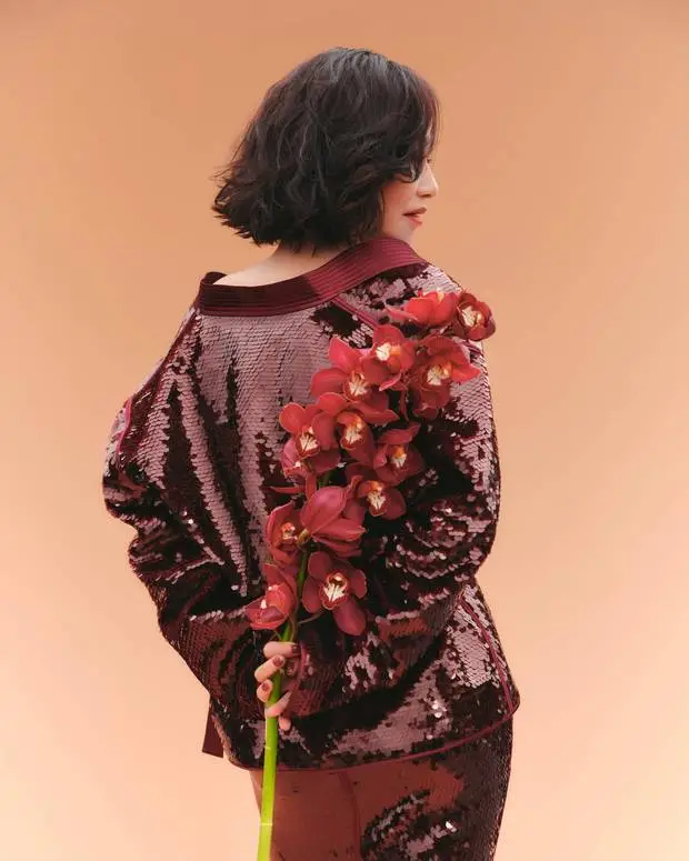 惠英红手持红花,背影窈窕。