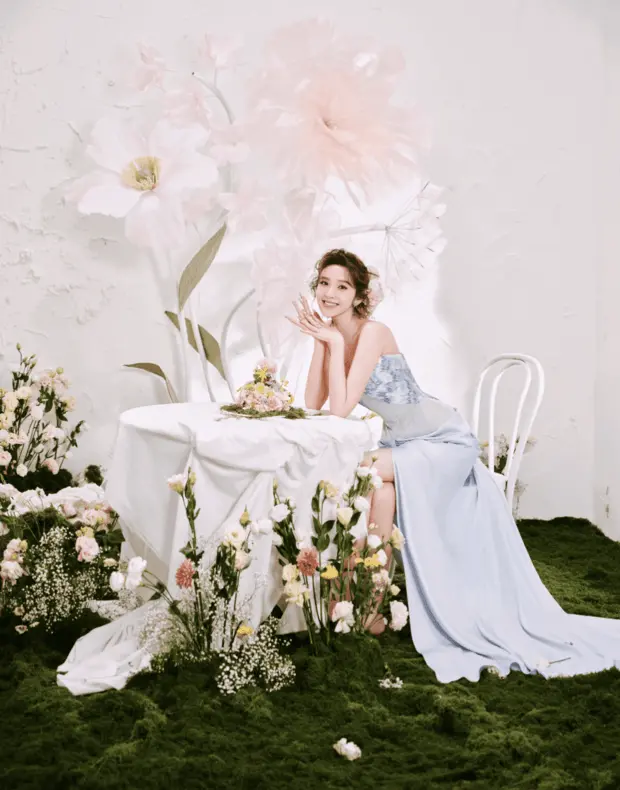 唐艺昕坐于花丛布景中，美丽大气。