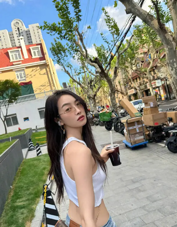 宋茜手捧咖啡散步，十分惬意。