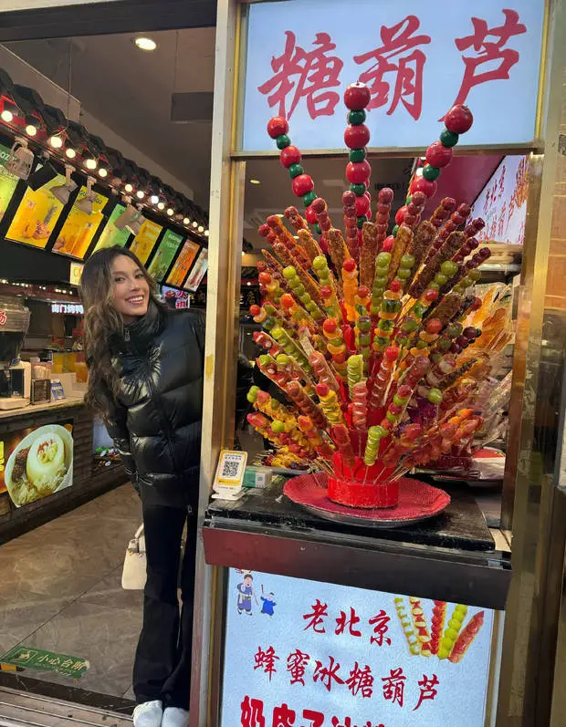 搜狐娱乐讯 2日，谷爱凌在社交平台上分享自己在北京生活的日常照，她在街上散步，驻足在老北京糖葫芦跟前拍照，面露甜美笑容，心情愉悦。