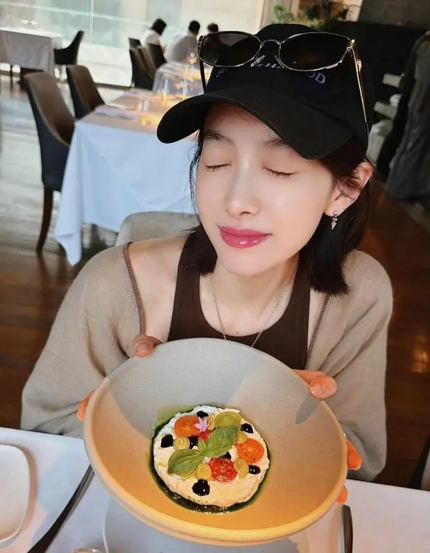 宋茜手捧菜品闭眼浅笑。