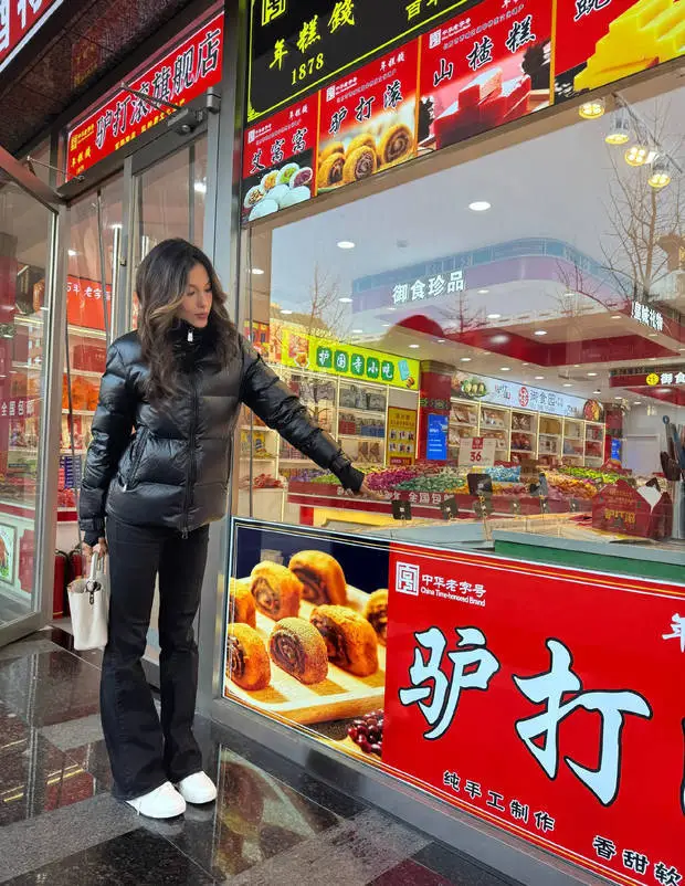 谷爱凌在糕点铺前拍照留念。