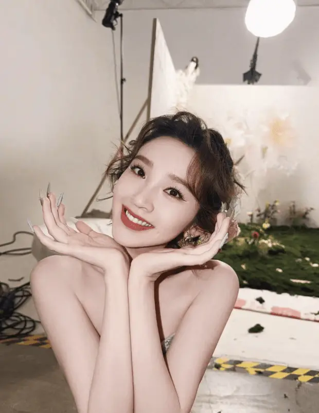 唐艺昕托腮甜笑，神态娇俏又温柔。