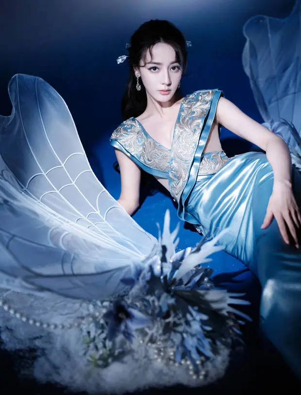 搜狐娱乐讯 5月19日，迪丽热巴工作室晒出了一组她的最新活动造型图，照片中她身穿一件缎面蓝裙。