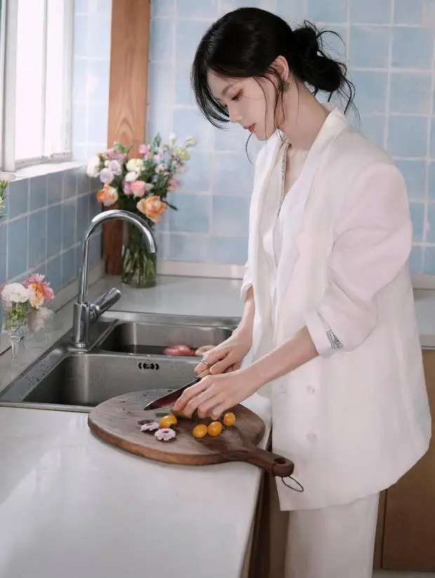 李一桐低头切水果，神情专注认真。