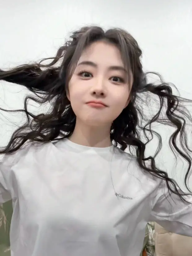 谭松韵把玩自己的卷发。