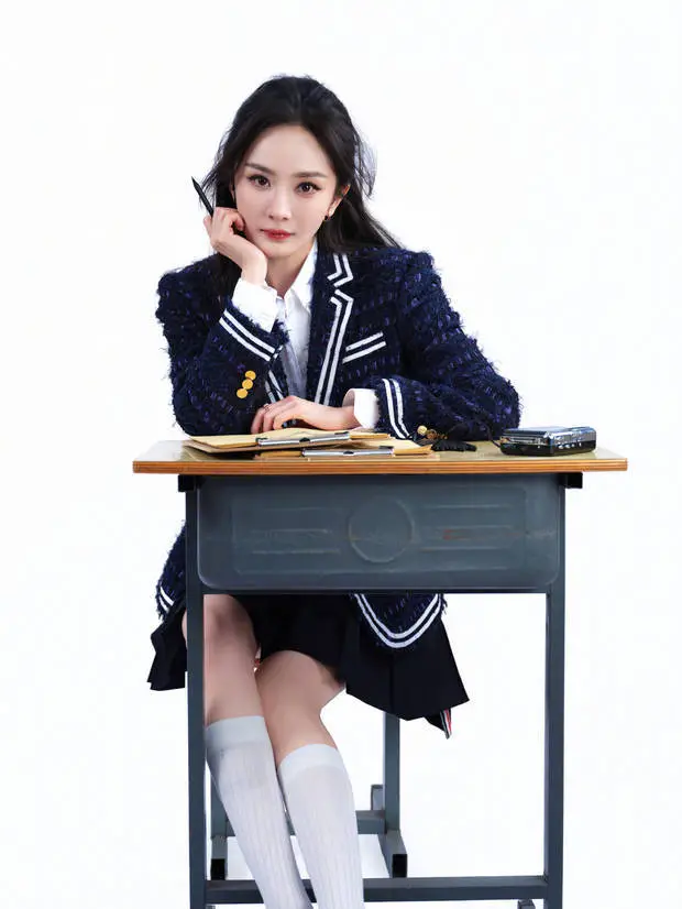 杨幂坐在课桌旁,仿佛认真听课做笔记的大学生。