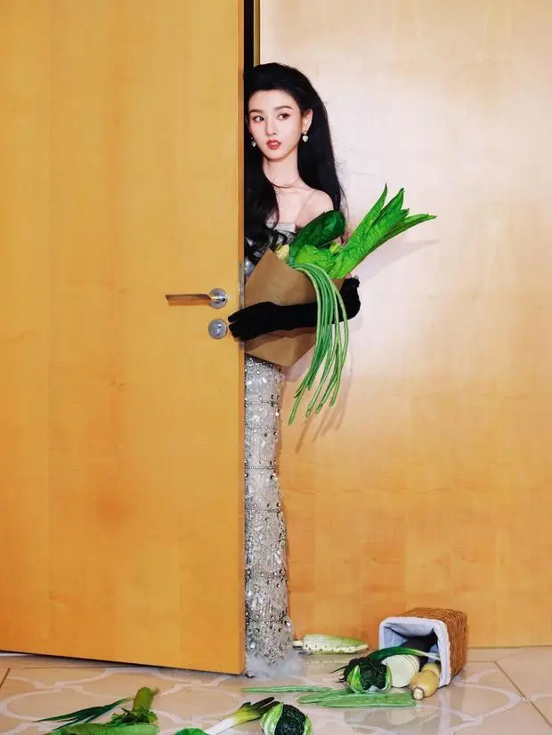 宋祖儿躲在木门后，手持蔬菜花束，眼神灵动。