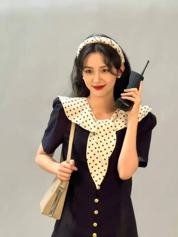 周也举大哥大微笑，俏皮可爱。