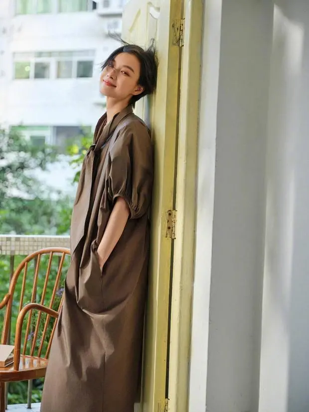 倪妮倚门，咖色长裙松弛感拉满。