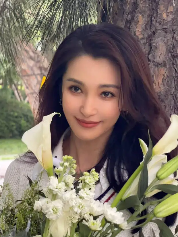 搜狐娱乐讯 近日，李冰冰现身品牌活动，身着简约白衬衫造型，手持百合漫步林间，生图美到到发光，气质优雅充满氛围感。
