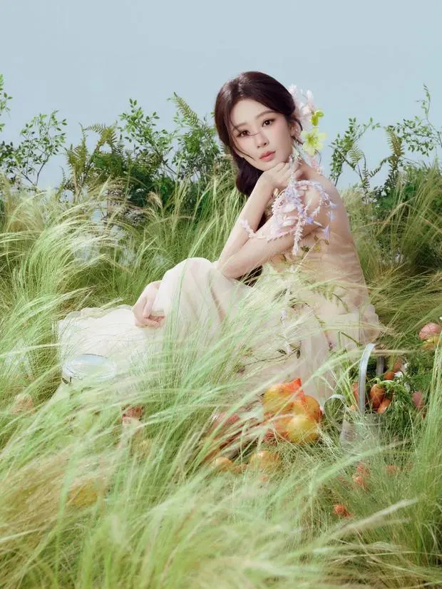 搜狐娱乐讯 1日，杨紫参加活动的最新造型写真释出，她身着斜肩轻纱裙优雅甜美，置身一片青草之中，十分清新自然！