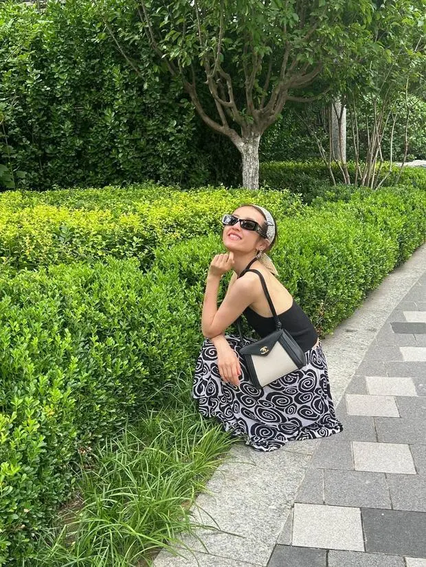 张子枫蹲在地上拍照，笑容满面，松弛感拉满。