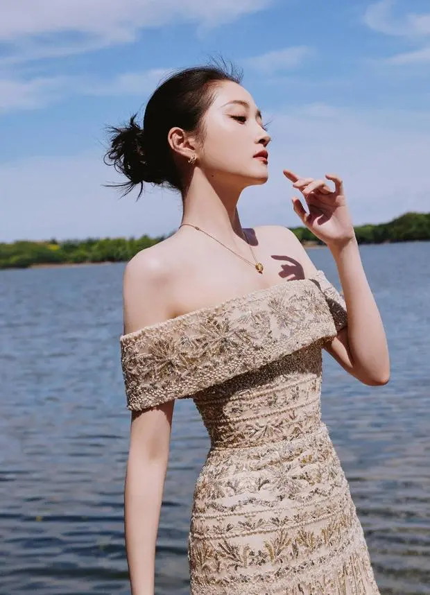 关晓彤侧身抬眸，水光与亮片裙呼应。