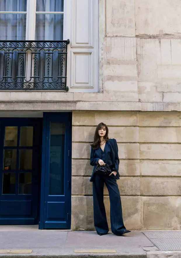 文咏珊倚墙而立，藏青西装时髦吸睛。