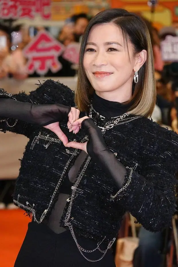 佘诗曼侧对镜头，双手比心。