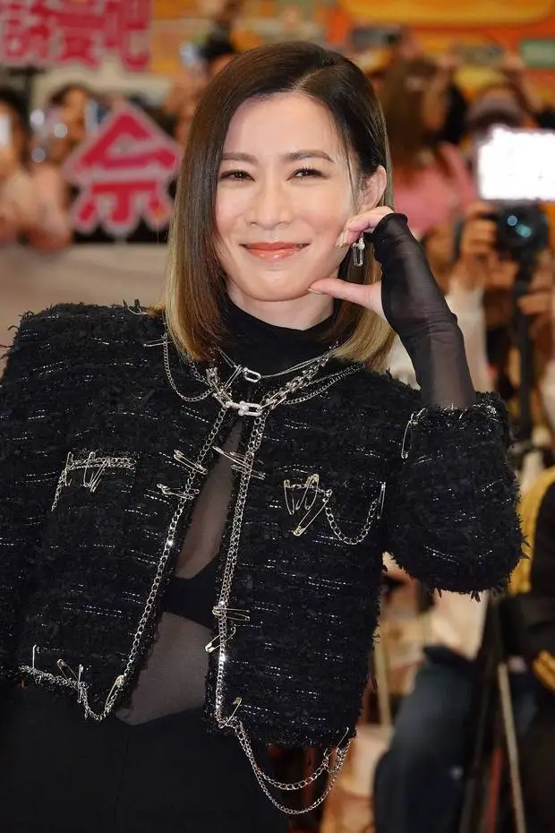 佘诗曼单手比心，笑容明媚。