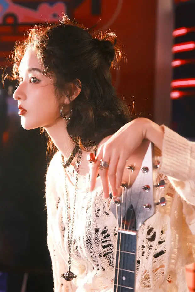 搜狐娱乐讯 27日，王玉雯在社交平台分享一组美图。图中，她抬手搭在吉他琴头，慵懒又带着复古松弛感。