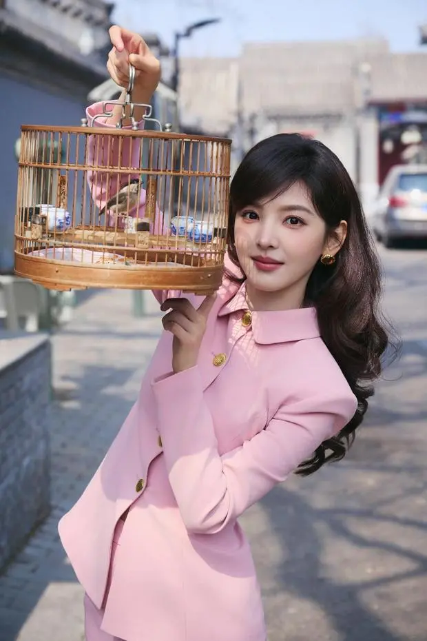 搜狐娱乐讯 3月25日，章若楠穿粉色套装现身活动，照片里的她漫步北京胡同，散发浓厚复古氛围。