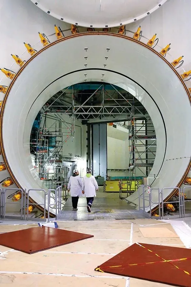 2018年11月22日，两名工作人员在芬兰奥尔基卢奥托核电站3号机组内走过高压门