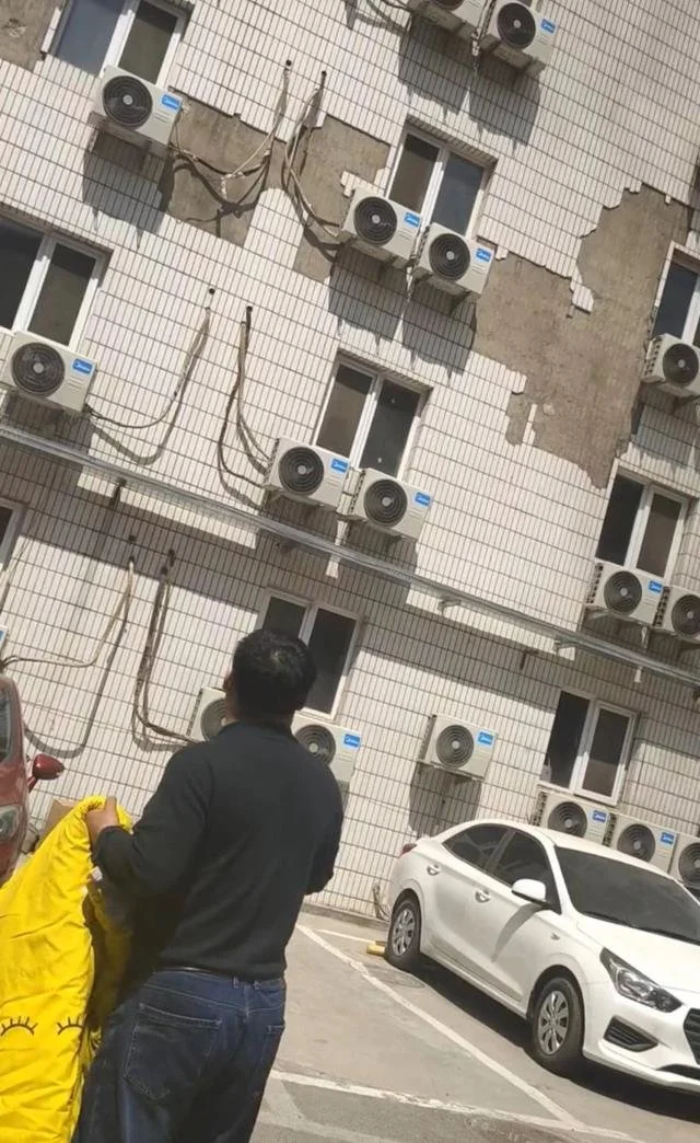 男子拿着被子，希望救助逃生者。受访者供图