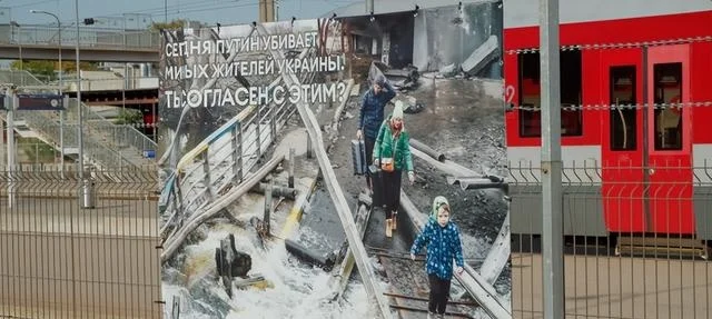 维尔纽斯车站站台上的图片中写着：“普京正在屠杀乌克兰平民，你同意吗？”