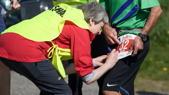 特蕾莎·梅弯腰为选手签名