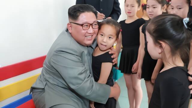 金正恩微笑着抱了抱小女孩
