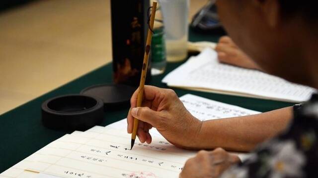 退休教师用毛笔写录取通知书