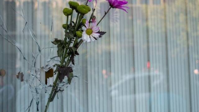 用鲜花堵住枪击后的弹孔