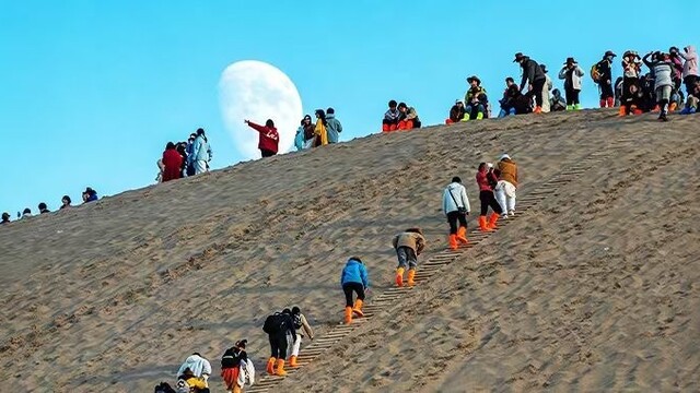 游客观赏月上敦煌鸣沙山