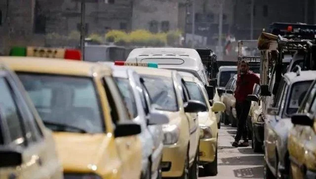 资料图：叙利亚街头，车辆排长队等待加油。