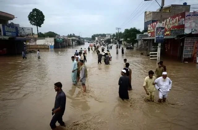◆ 8月27日，人们在开普省白沙瓦的洪水中蹚水行走。