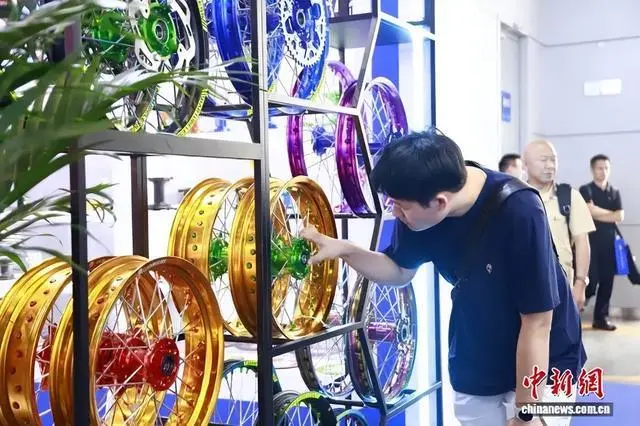 2025中国摩博会在重庆举行。图为民众前来展厅参观摩托车零部件。马佳欣 摄