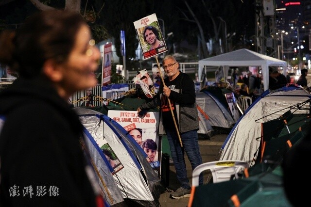 当地时间12月18日，以色列特拉维夫，巴以冲突持续，人质家属和支持者在基里亚军事基地外抗议，呼吁释放遭哈马斯劫持的人质。图自澎湃影像