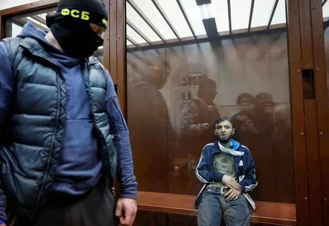 3月24日，枪击事件嫌疑人之一坐在法院的被告席玻璃墙后面