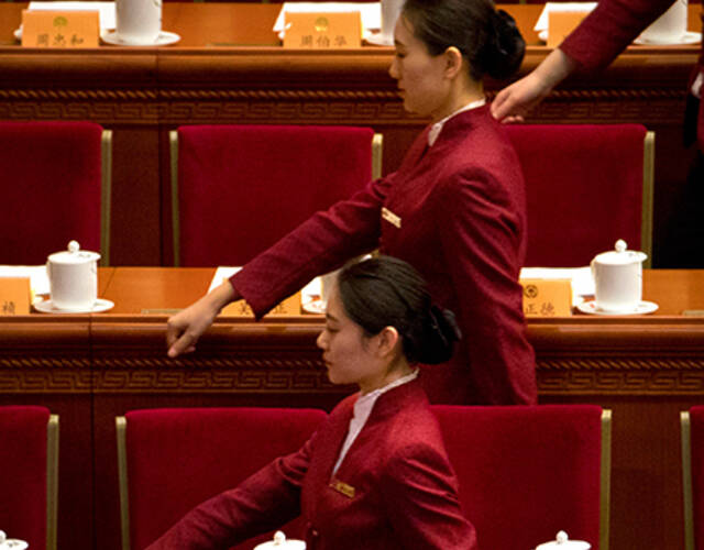 北京,会议正式开始前,服务员在拿着水壶为委员们准备茶水