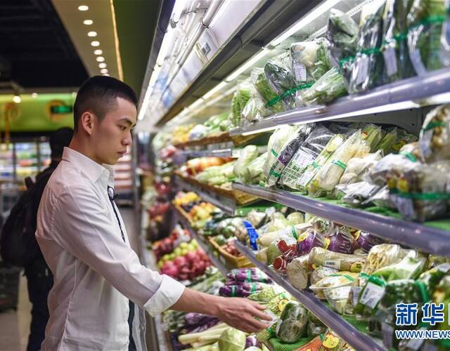 在深圳的一家超市,陈熙文在挑选食材准备做饭(5月25日摄).