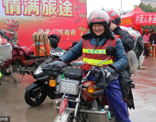 图为张女士搭着丈夫,从广东中山市冒雨赶回广西平南县老家.