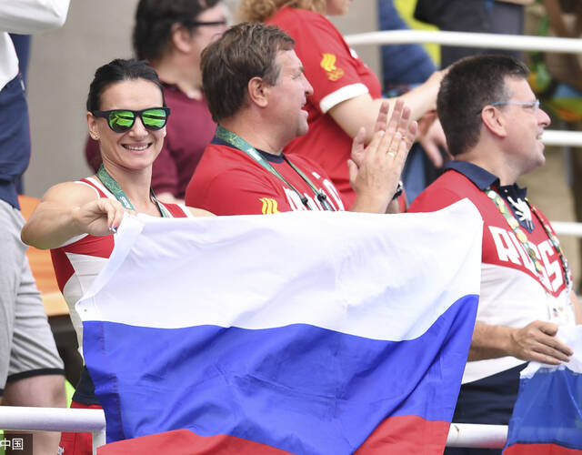 手持国旗为俄罗斯花游队助威