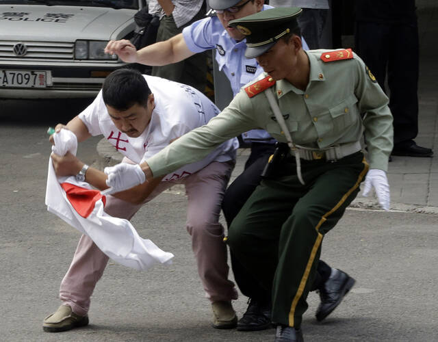 2012年9月10日,北京日本大使馆门口,一位民众想点燃日本国旗,被中国