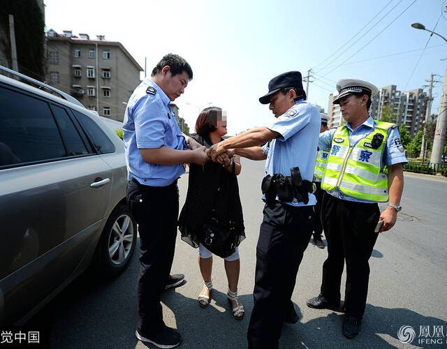 警察只好通过强制措施将其带上警车,坐在警车内的女司机仍然不肯罢休