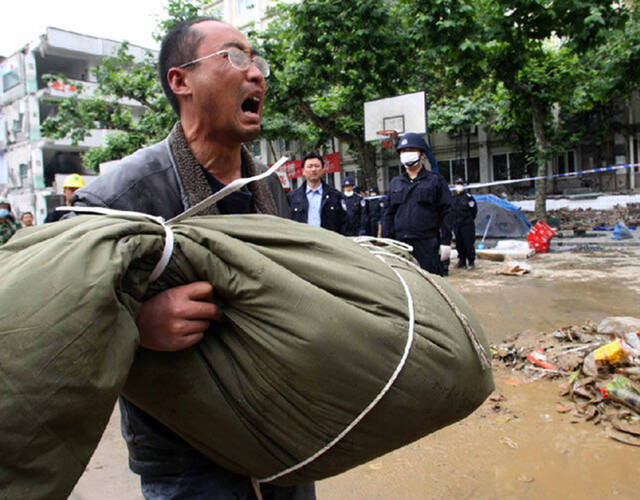 2008年5月14日,都江堰新建小学,赵建中抱着9岁儿子的遗体,失声痛哭.