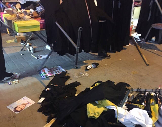 摊主衣服被扔到地上.