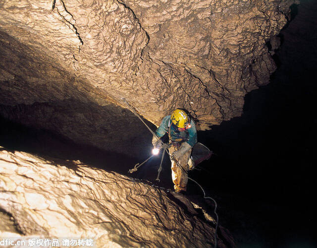 图中是一名探险家正小心翼翼地向下探索.