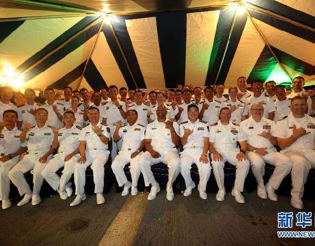 当地时间12月15日晚,中美海军官兵在美海军举行的甲板招待会上合影