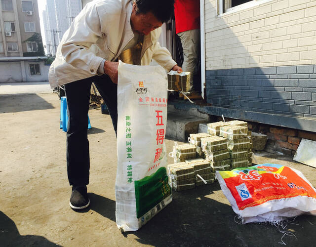 在清点完毕后,他们又将钱装回编织袋,并进行了封口,记者用一只手拎