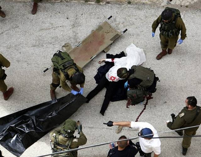 图为以色列安全部队搬运巴勒斯坦女孩的尸体.